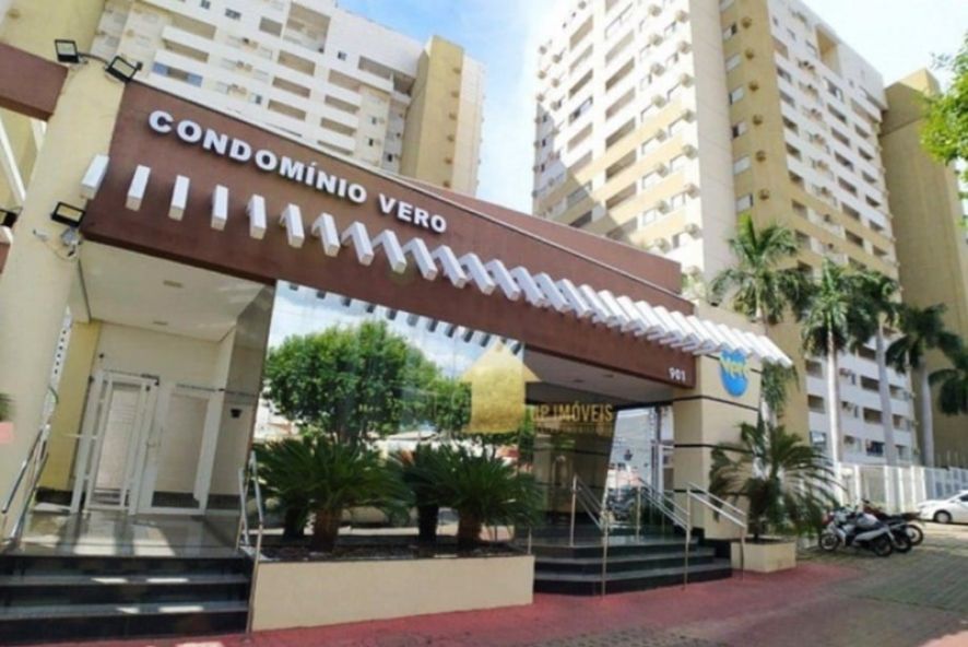 Entrada moderna de condomínio residencial com manutenção predial adequada, mostrando fachada em tons neutros e torres com varandas cercadas por paisagismo
