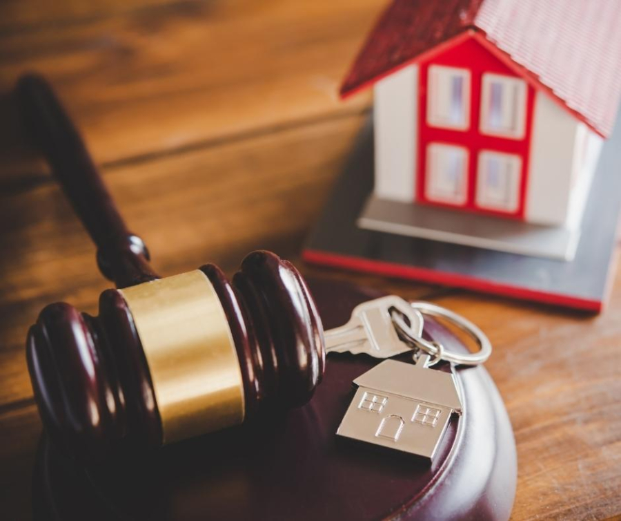 Martelo de juiz e chaves de imóvel representando decisão STJ sobre penhora de imóvel financiado por dívida condominial